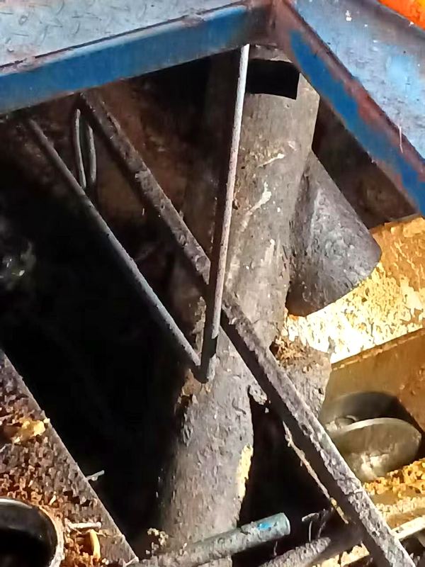 Bin discharge: material cakes and bridges at the outlet, often needing manual poking to fall