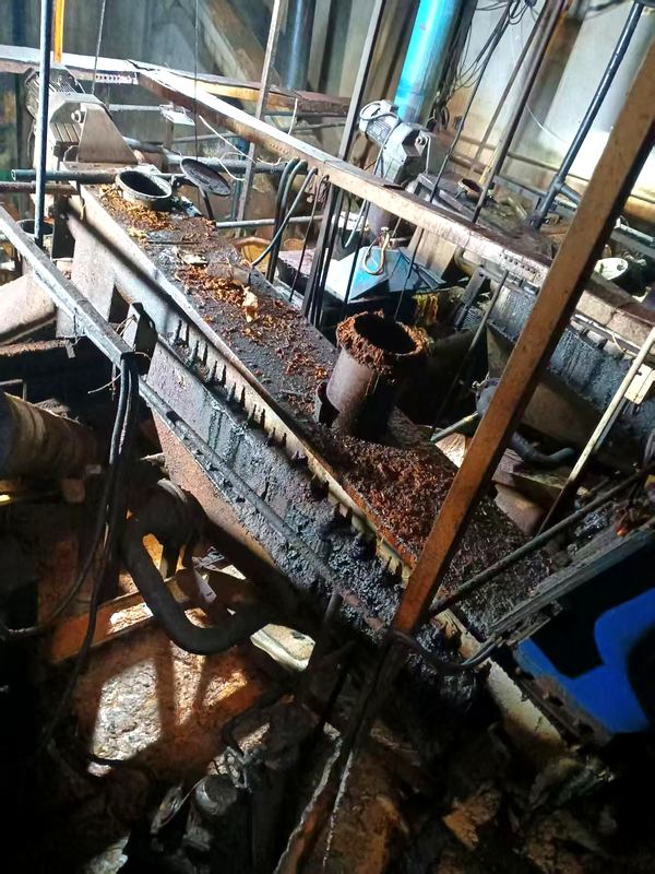 Dewatering conveyor: the long trough leaks along its length, floor is wet and slippery, cleaning requires going to the trough side